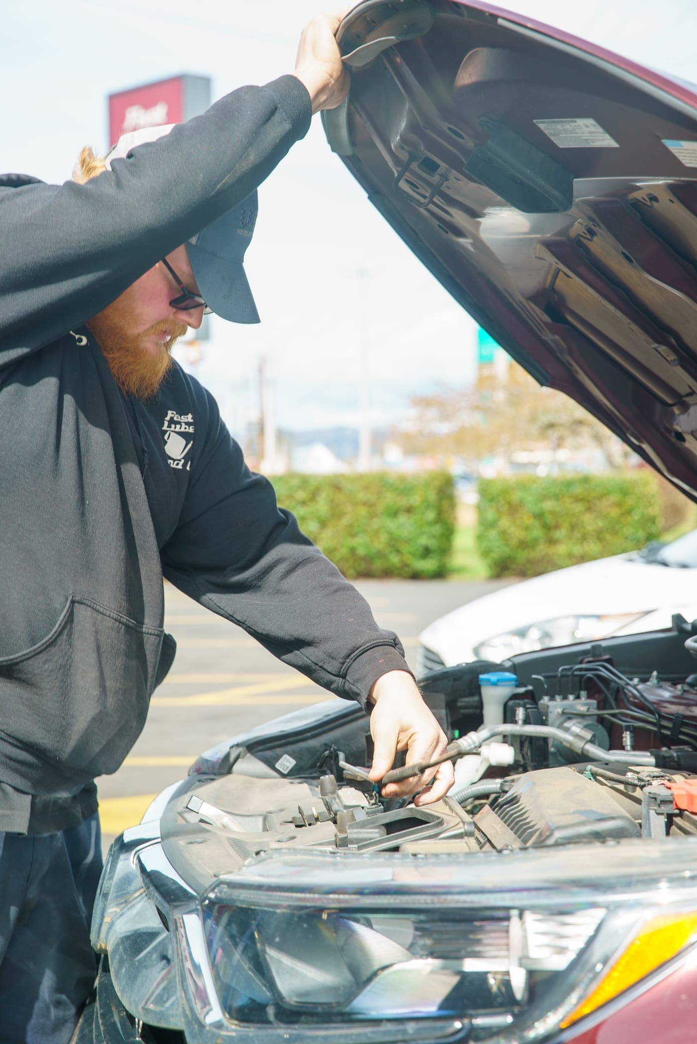 A Fast Lube & Oil technician working under the hood