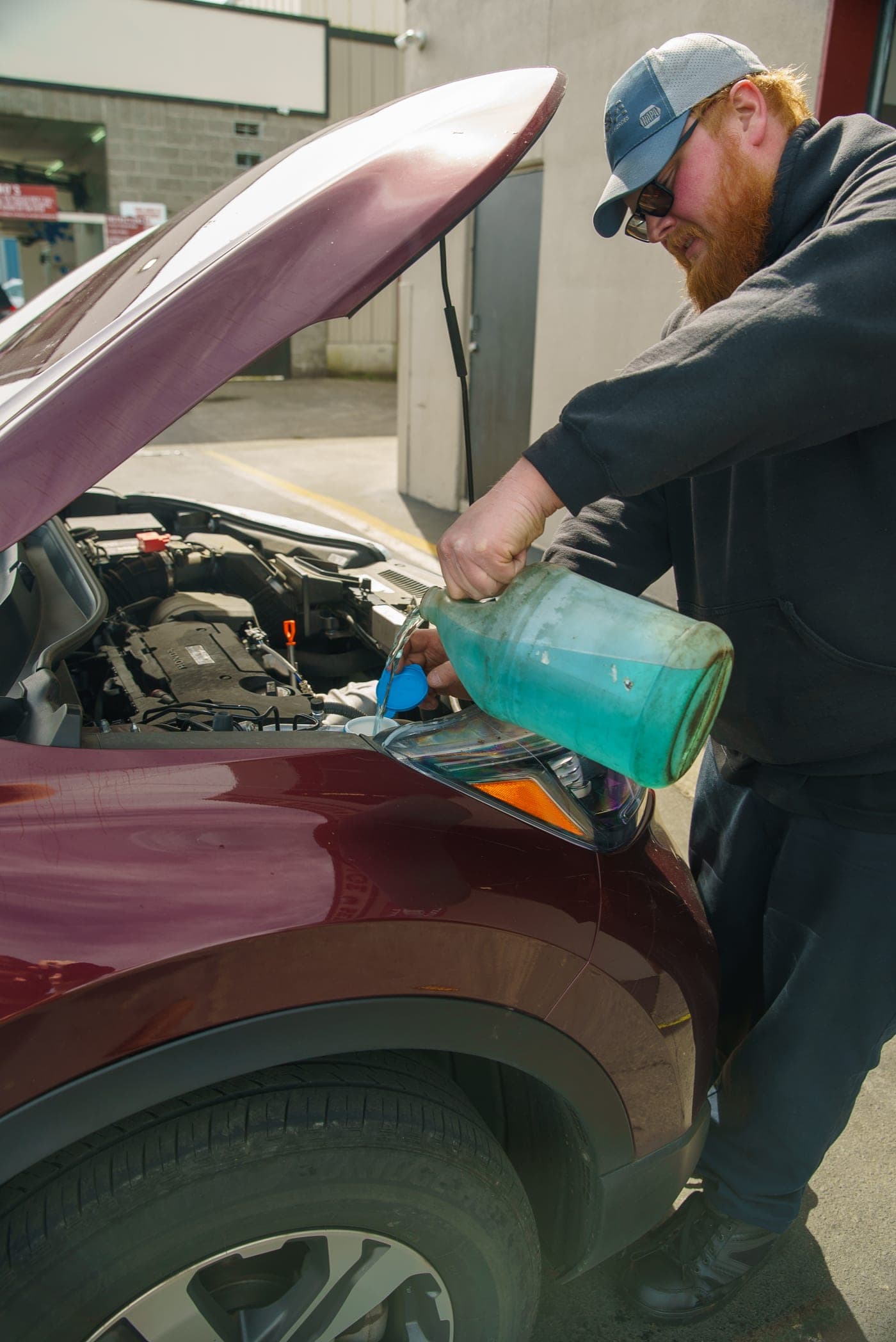 A technician adding fresh fluid during a service in Warrenton